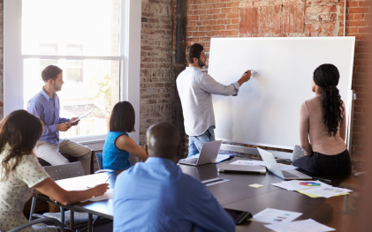 Employees around a whiteboard